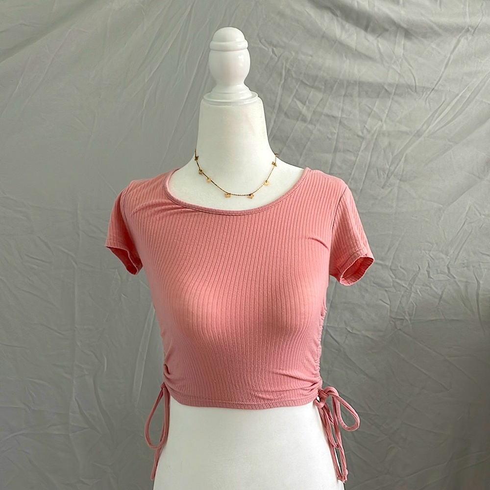 Pink stretchy shirt, with adjustable ties for the length.